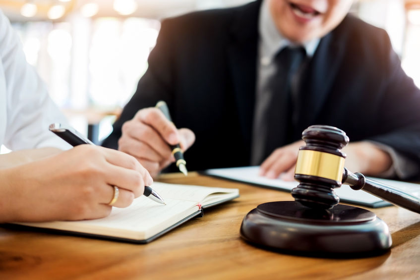 two men discussing contract papers with gravel on wooden table