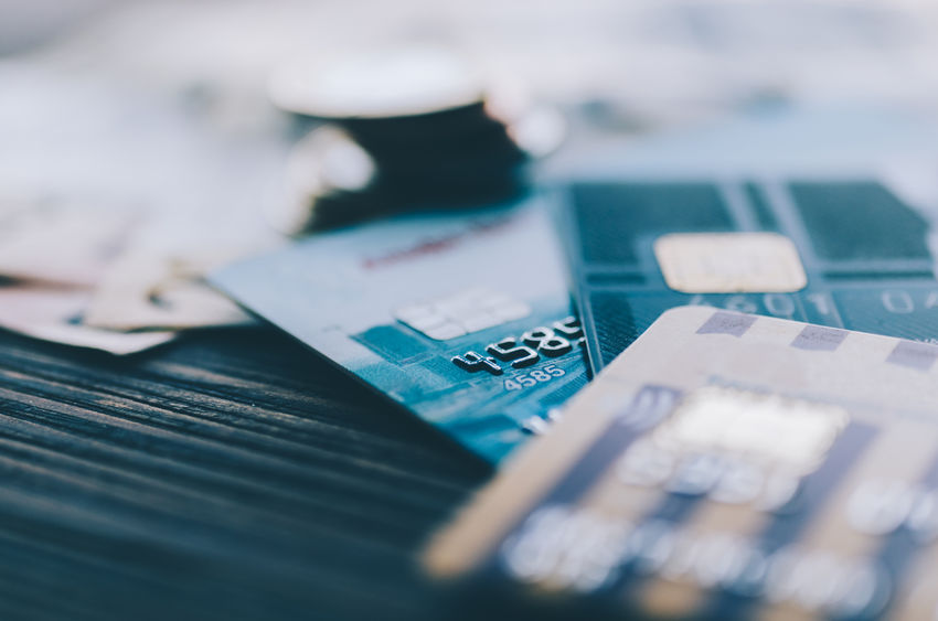 Credit card, coins and money on the table in reference to credit card surcharge