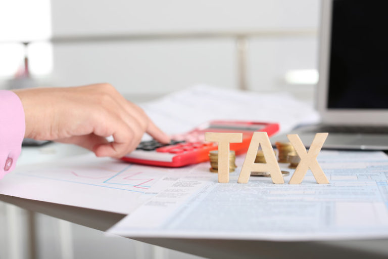 Young female calculating taxes at table, closeup