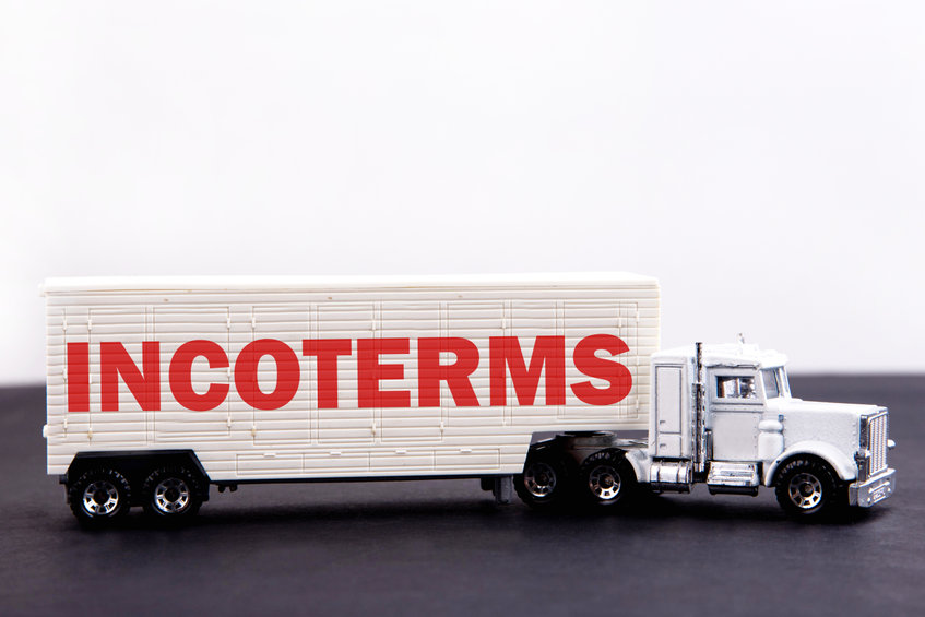 Incoterms word concept written on board a lorry trailer on a dark table and light background