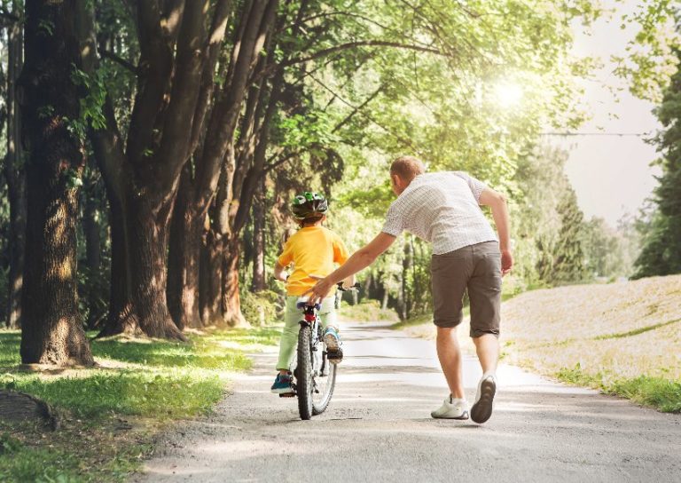 Father and son learning how to ride a bicycle