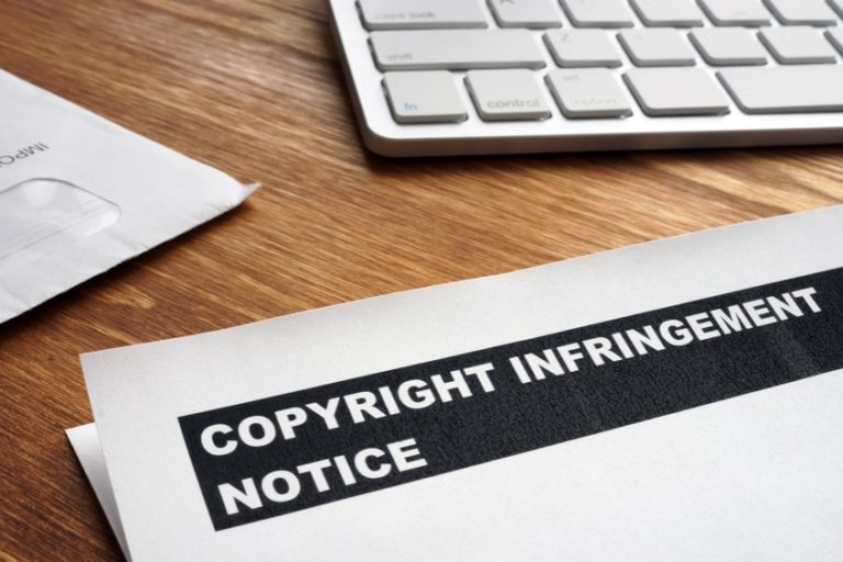 Picture of a letter with copyright infringement notice on a desk.