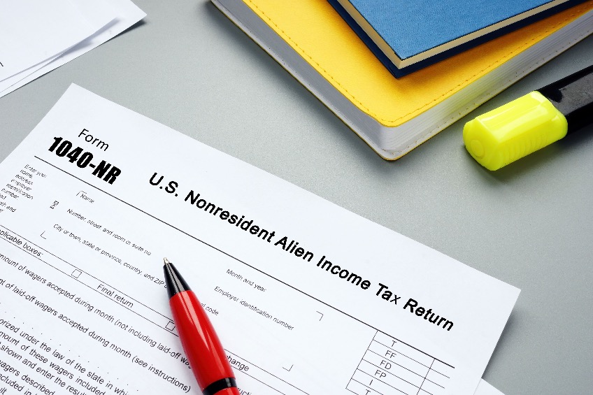 Picture of Nonresident Alien Income Tax Return with sign on the piece of paper.