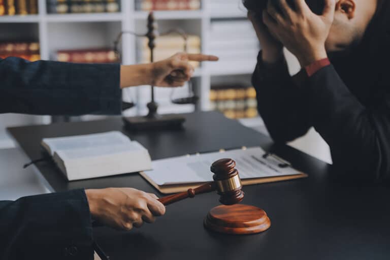 At the same table, a judge deliberates while another individual rests their head in their hands, appearing distressed, representing FLSA